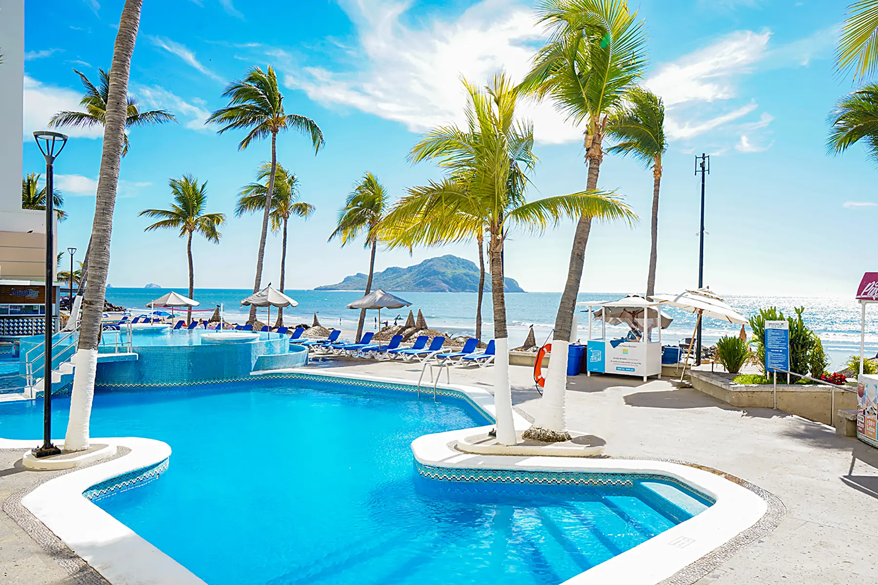 Alberca con vista la mar al aire libre y palmeras de hotel Oceano Palace Mazatlán